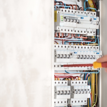 electrical-technician-working-switchboard-with-fuses-985b54ba012e09e5df3fb10766cbcba5.jpg